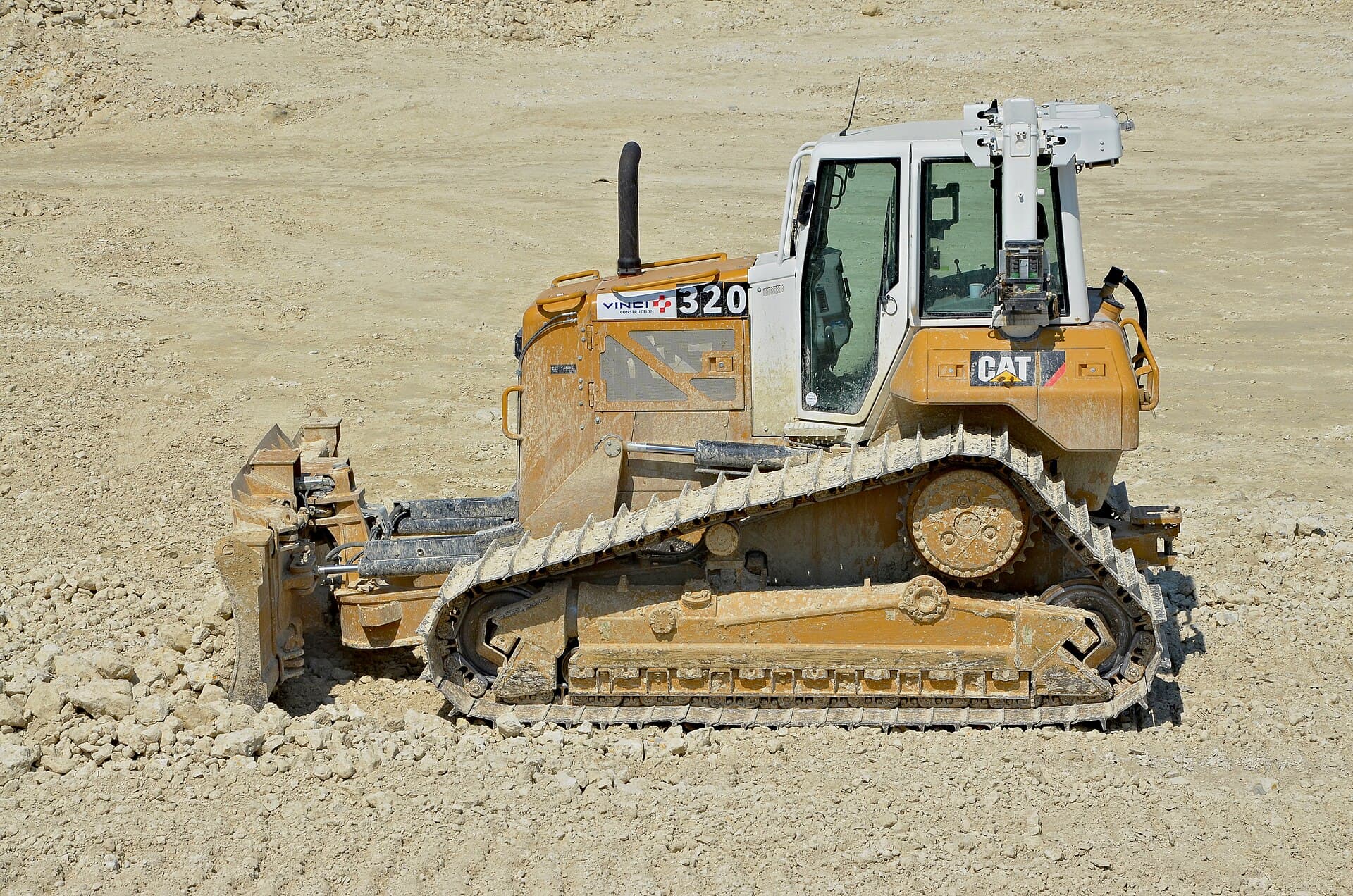Tracked bulldozer spreading fill on a mine haul road