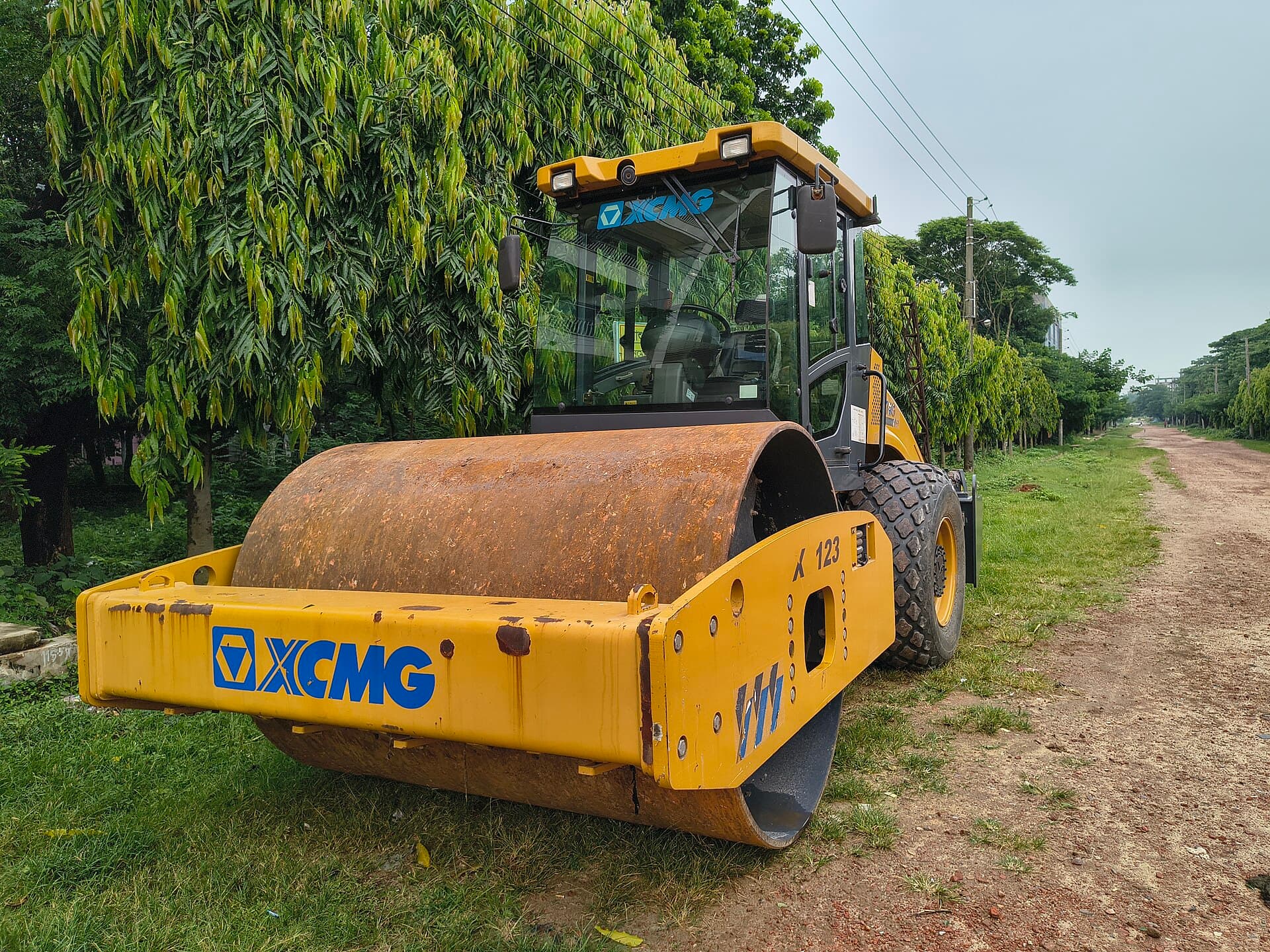 Single-drum vibratory roller compacting a laterite mine road